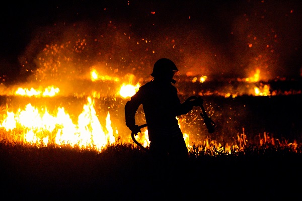 Pompier éteignant un feu dans un champ